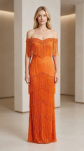 Front view of woman wearing orange off-shoulder beaded fringe evening gown
