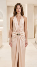 Front view of Champagne halter plunge backless satin maxi dress with front slit and metallic buckle