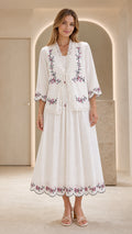 Front view of model wearing white embroidered two-piece dress and jacket set