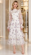 Front view of woman wearing ivory white tiered tulle midi dress with purple 3D butterflies