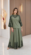 Front view of model wearing Sage Green modest two-piece top and maxi skirt set with black floral border print