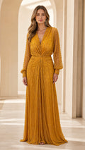Front view of model wearing mustard yellow beaded long sleeve evening dress