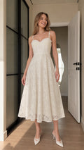 Front view of model wearing ivory floral lace corset midi dress with sweetheart neckline