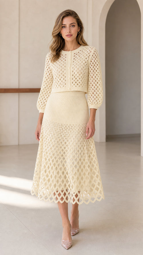 Front view of model wearing cream open-knit cardigan and matching midi skirt set