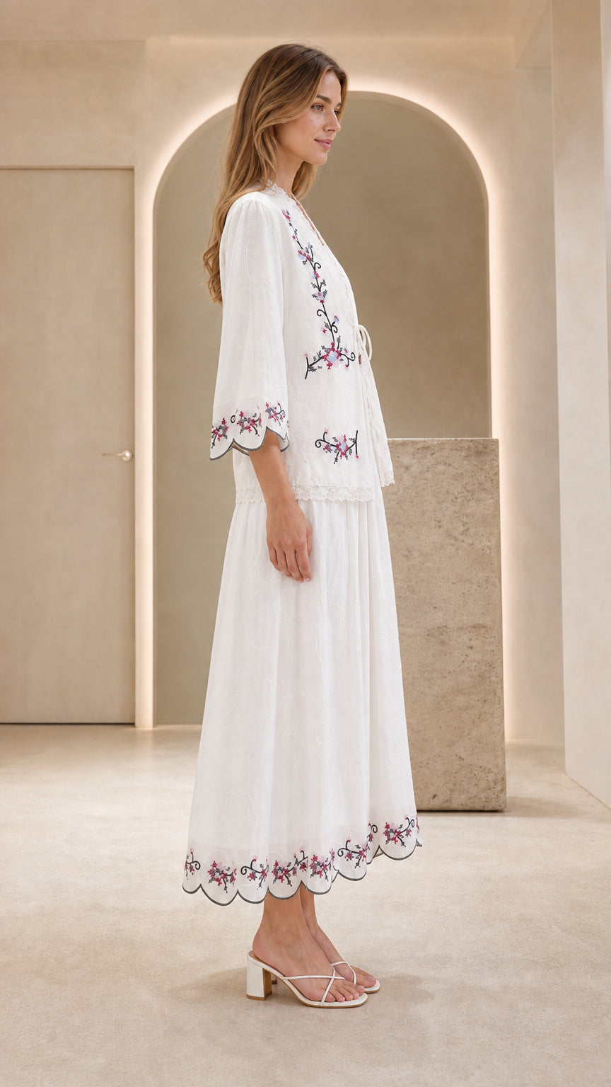 Side profile view of model in white embroidered dress set