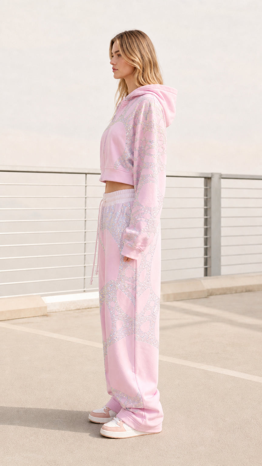 Side view of model wearing pastel pink cropped hoodie and baggy sweatpants