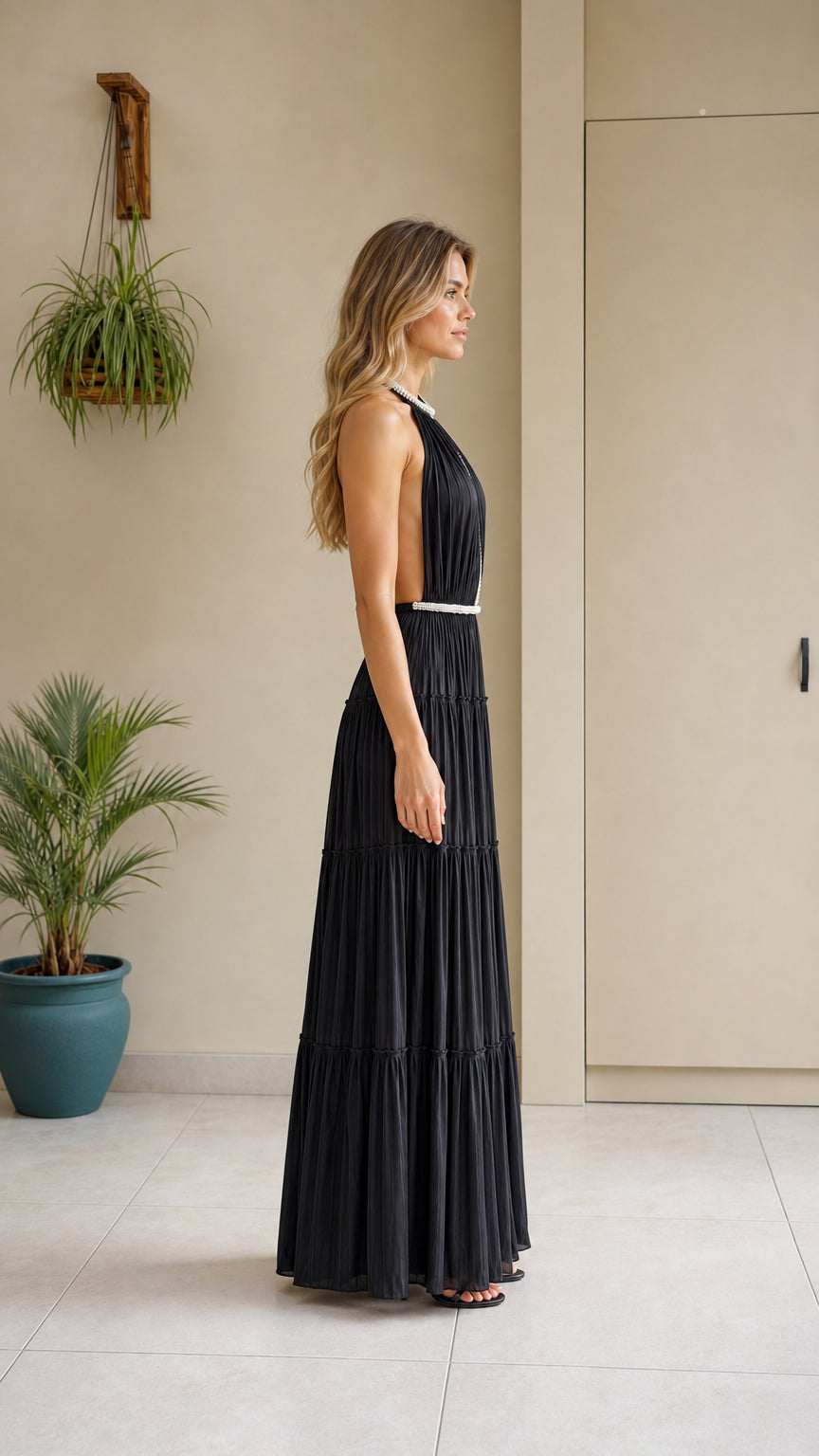 Side profile view of the black pearl trimmed pleated maxi dress