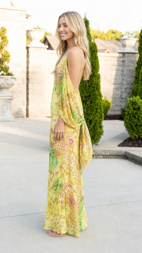 Side profile of woman wearing yellow printed open-back slip maxi gown