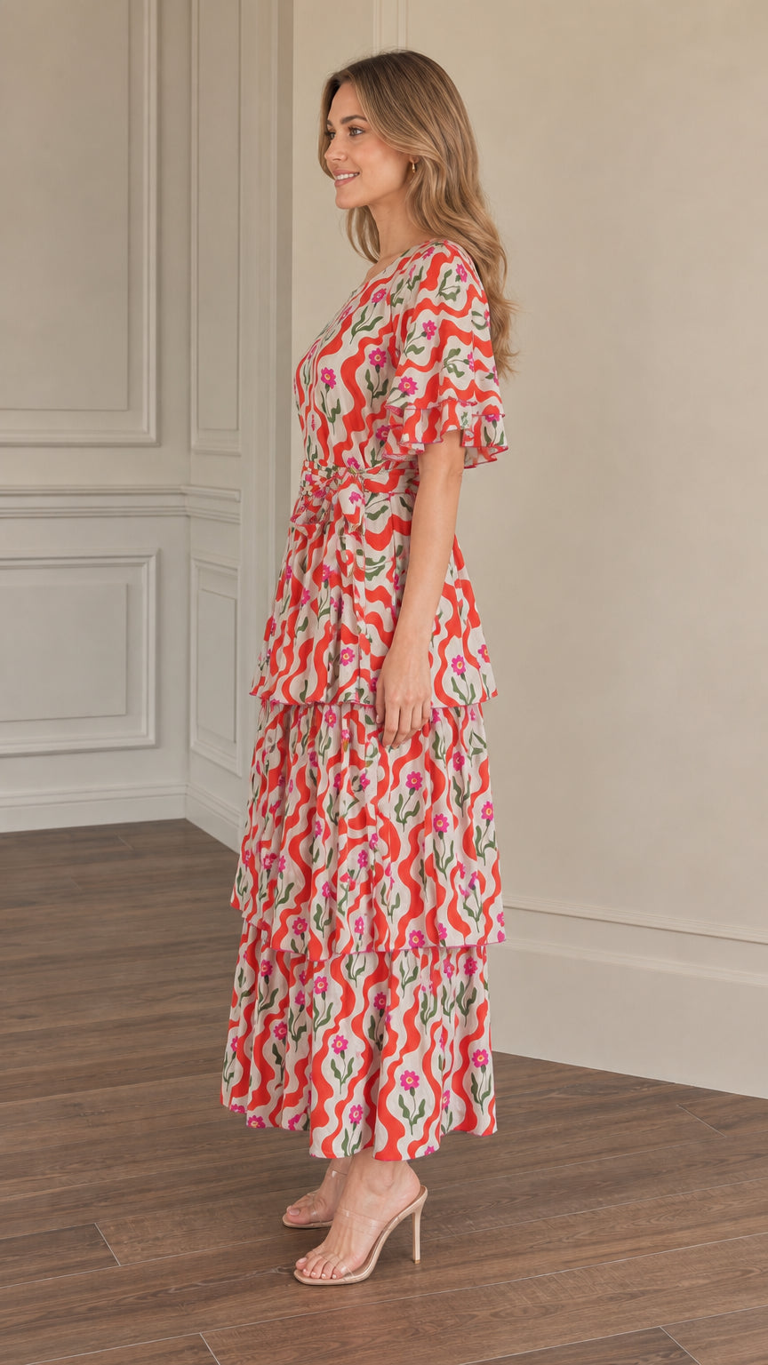 Side full-length view of woman wearing red floral wave print tiered maxi dress