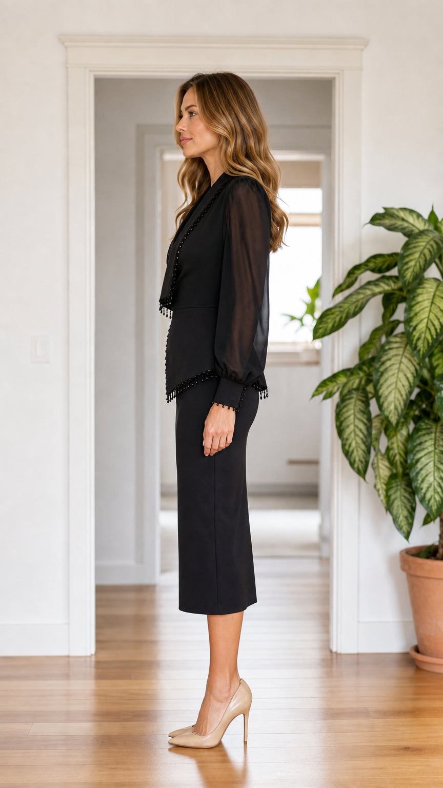 Side profile of woman wearing black wrap midi dress with chiffon sleeves