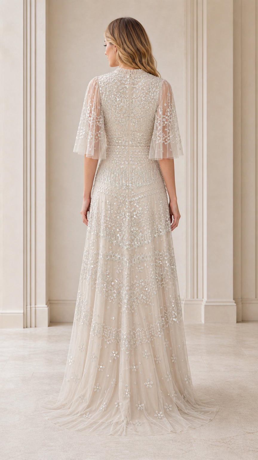 Back view showcasing sheer flutter sleeves and sweep train of champagne dress