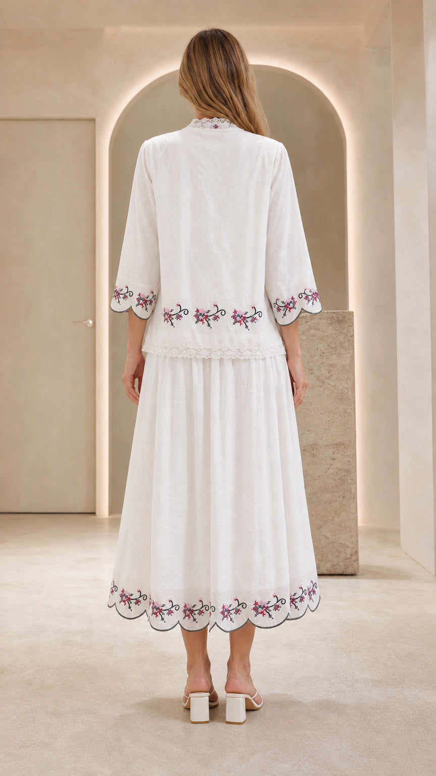 Back view of model showing embroidered details on white dress set