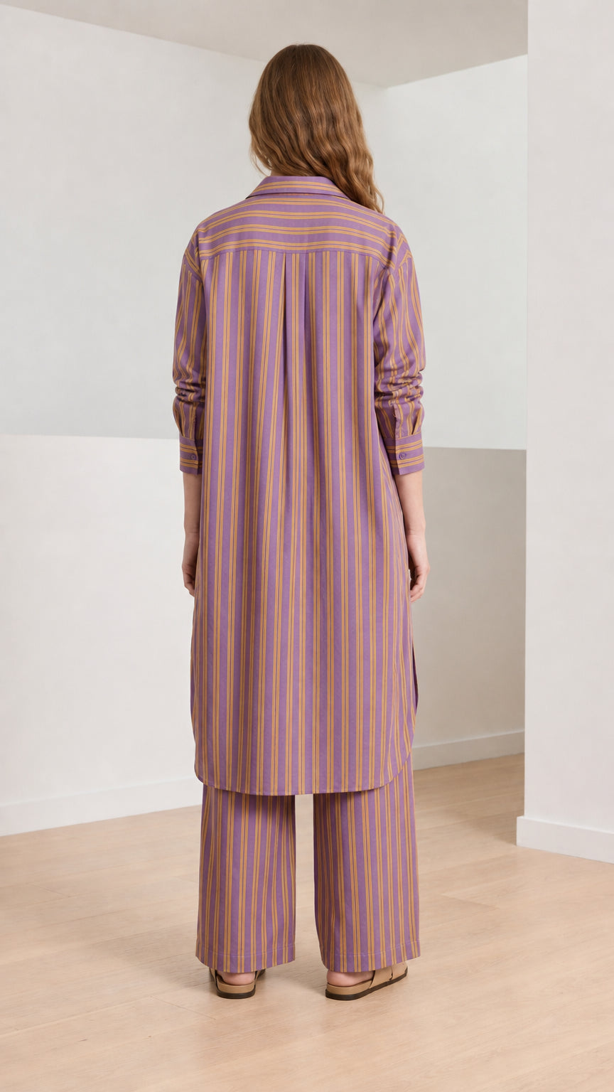 Woman wearing purple striped longline shirt and wide-leg pants back view