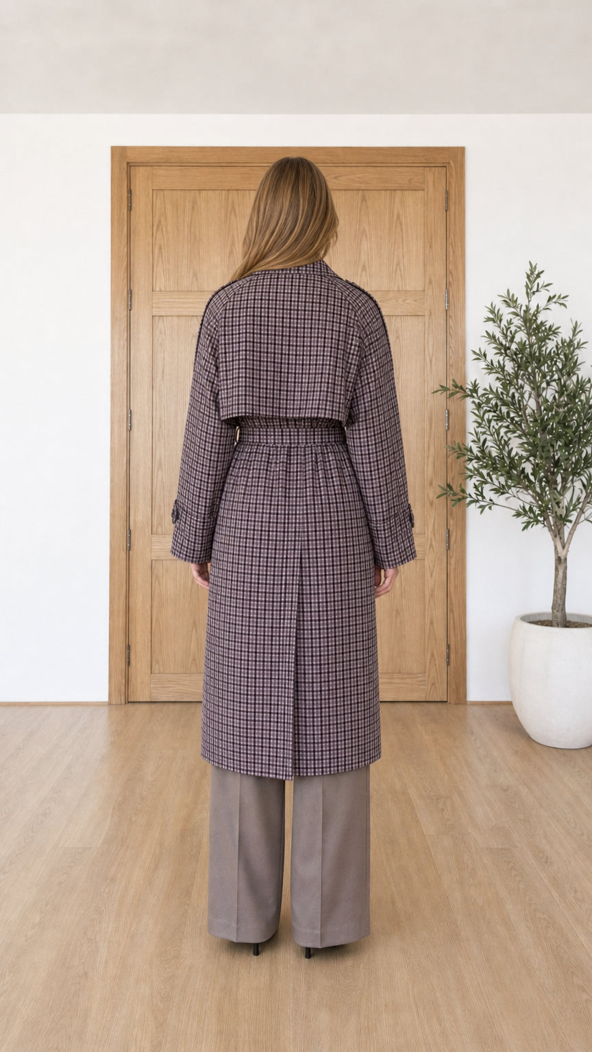 Back view of woman wearing long purple plaid trench coat