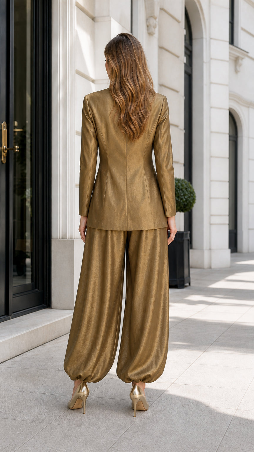 Model wearing metallic gold pant set, back view