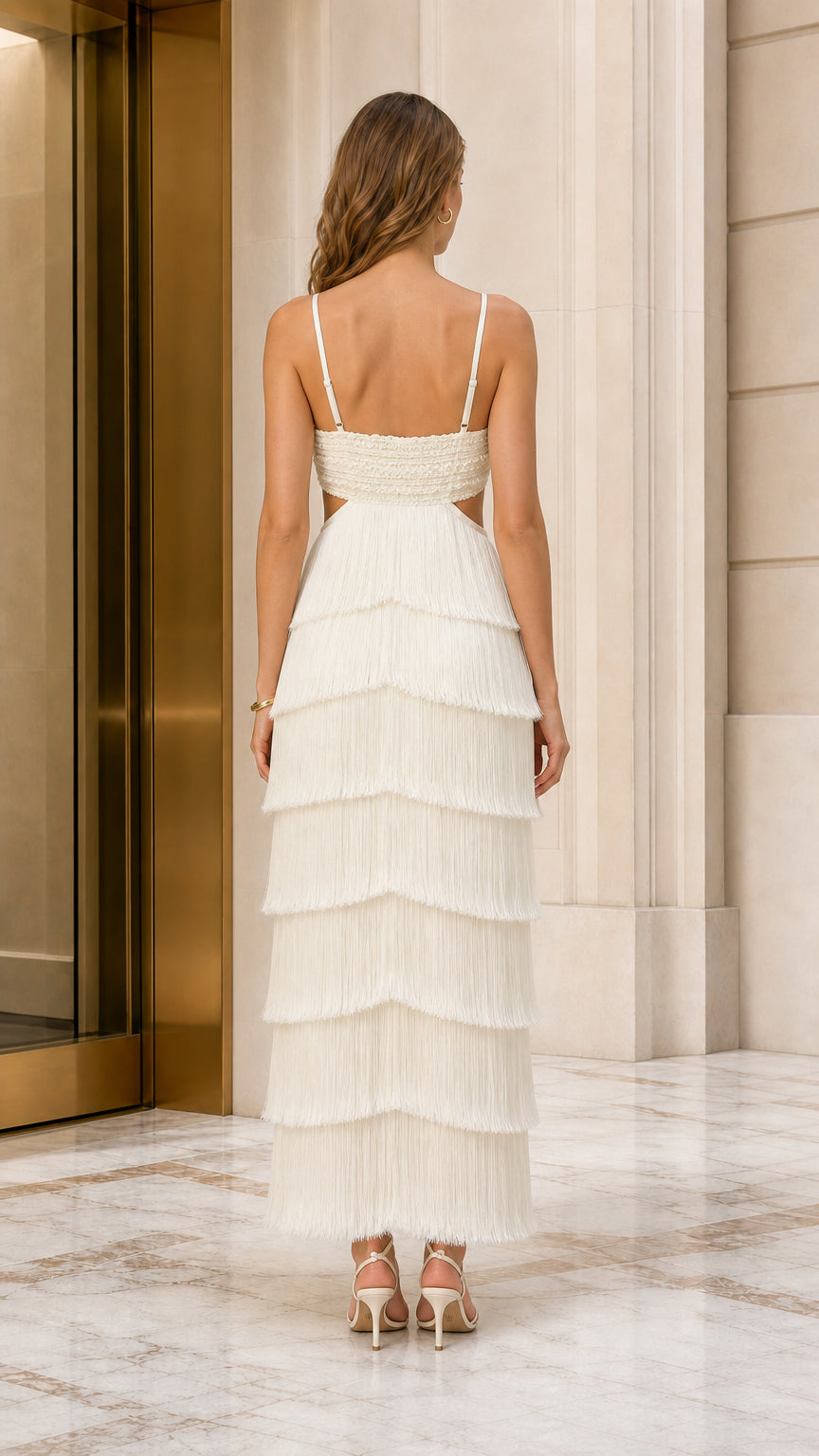 Back view of ivory cutout fringe maxi gown showing strappy open-back detail