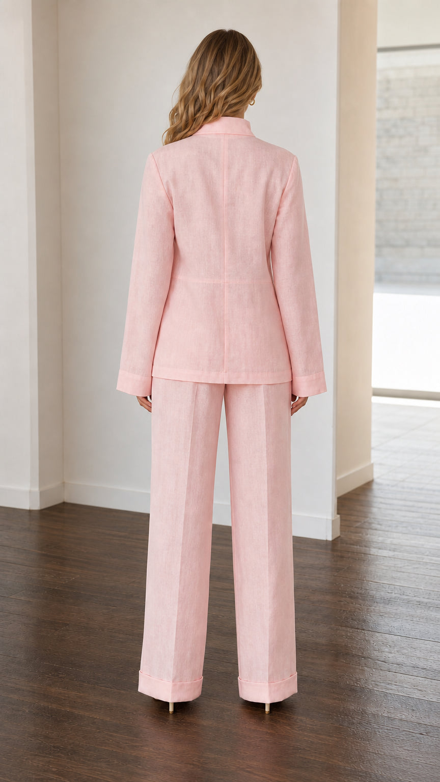 Back view of woman wearing Light Pink tailored jacket and wide-leg trousers