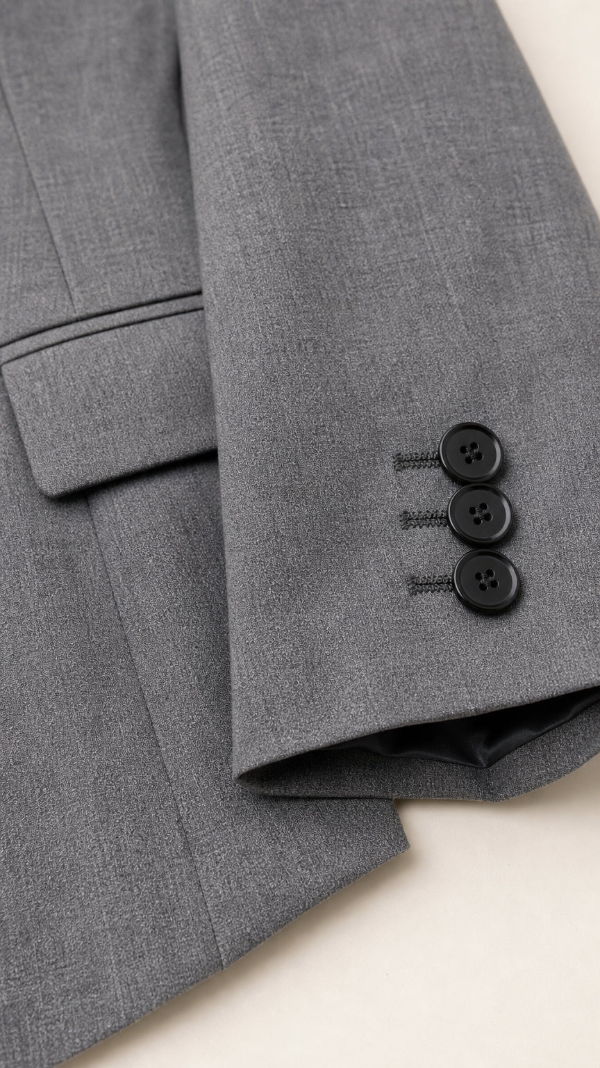 Close-up detail of grey blazer sleeve cuffs and button details