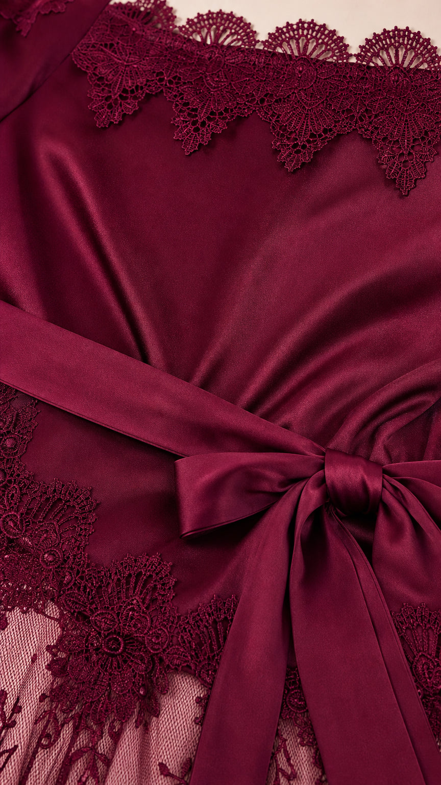 Close up detail of burgundy satin bodice lace trim and waist tie ribbon