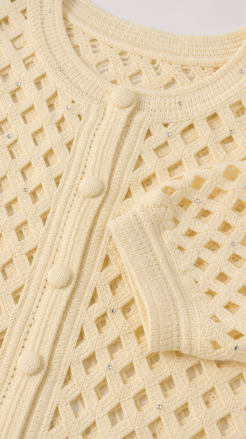 Close-up detail of cream cardigan texture, buttons, and subtle embellishments