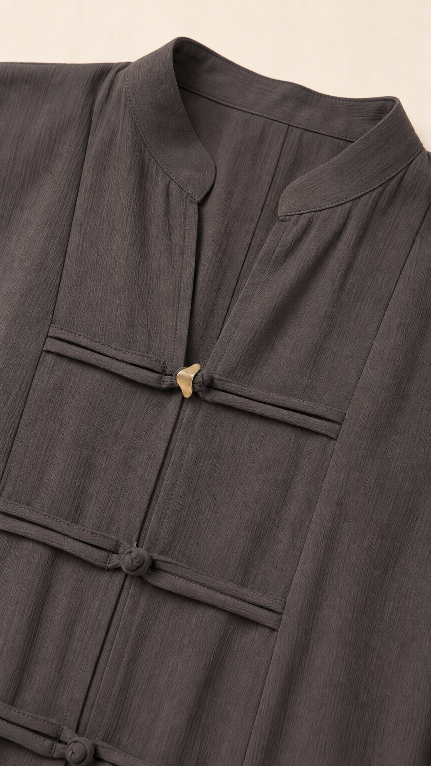 Close-up of mandarin collar and knot details on dark grey dress