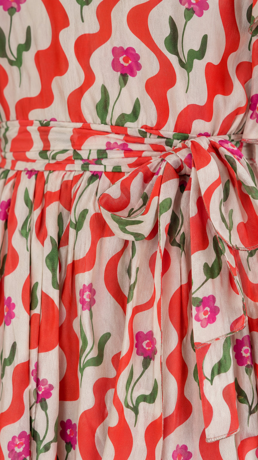 Close-up detail of red floral wave pattern and tied sash waistband