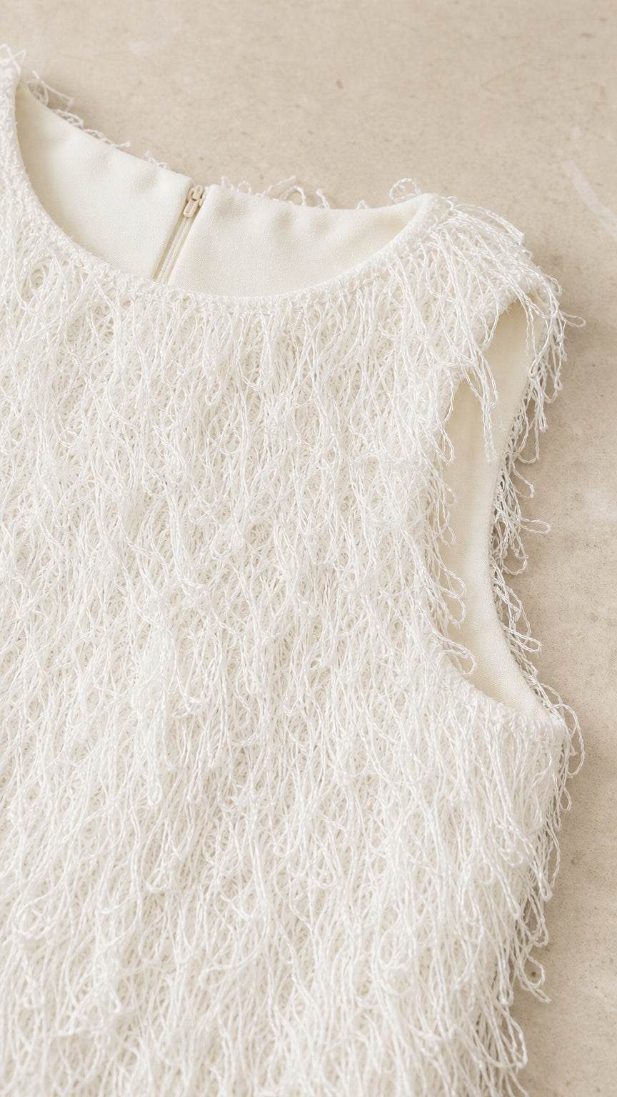 Close-up detail of white fringe textured bodice and neckline
