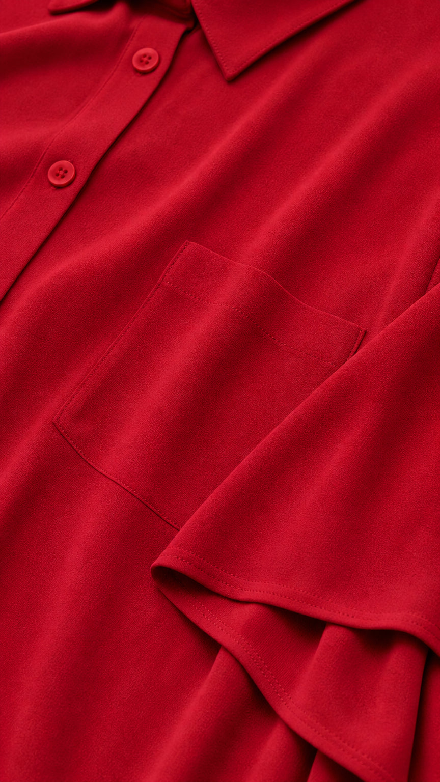 Close-up of red fabric, collar, buttons, pocket, and sleeve detail