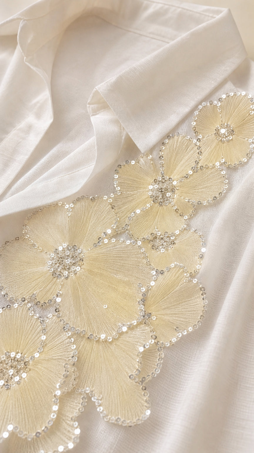 Close-up detail of floral lace embroidery and sequin accents on shirt collar and placket