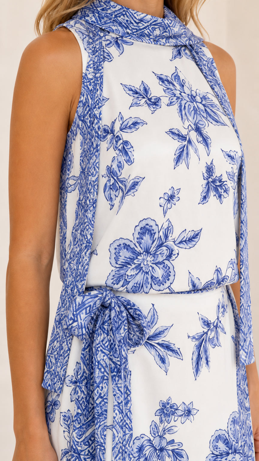 Close-up of high neckline and floral print pattern on white dress