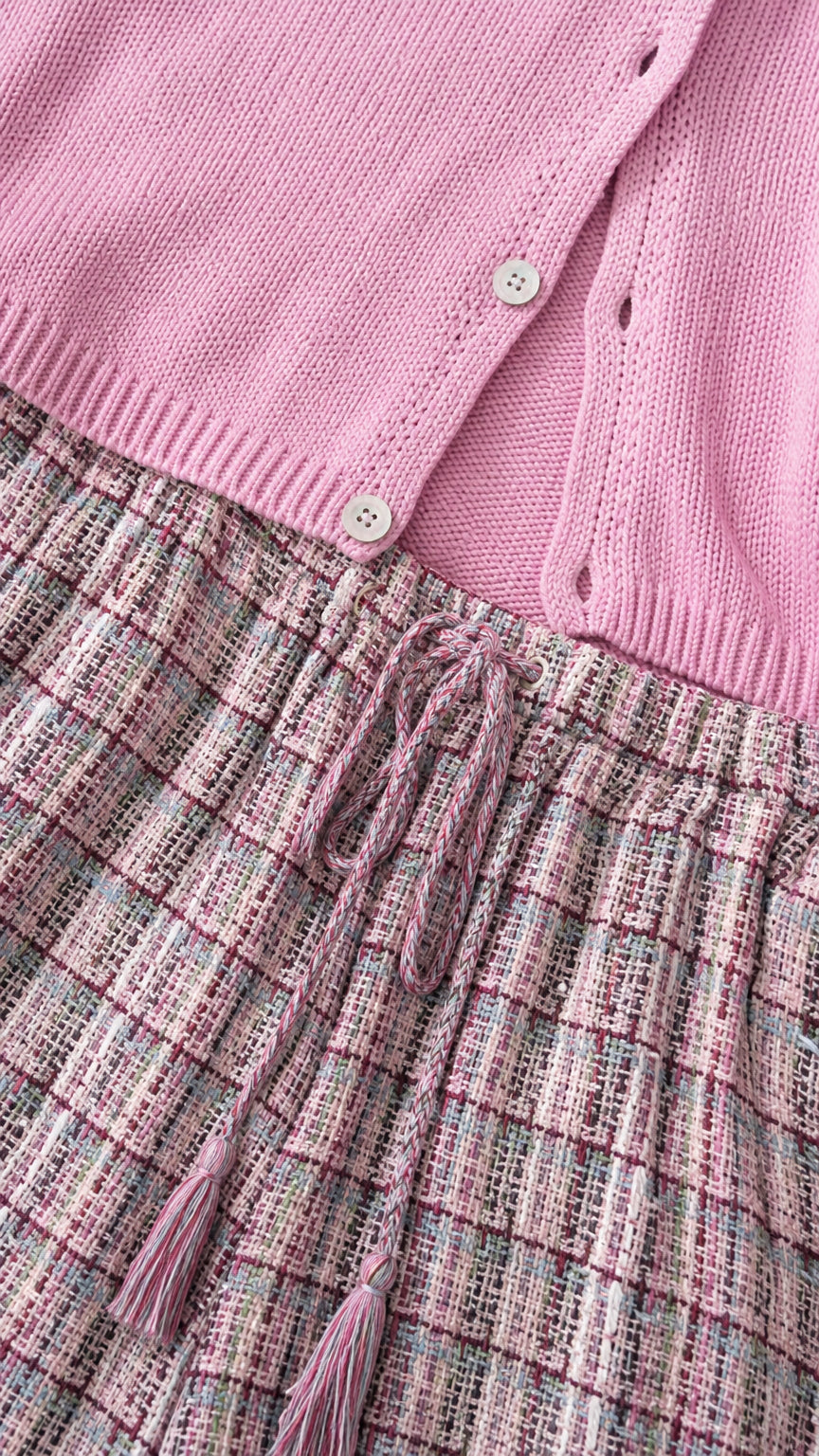 Close up of pink cardigan buttons and patterned trouser waistband