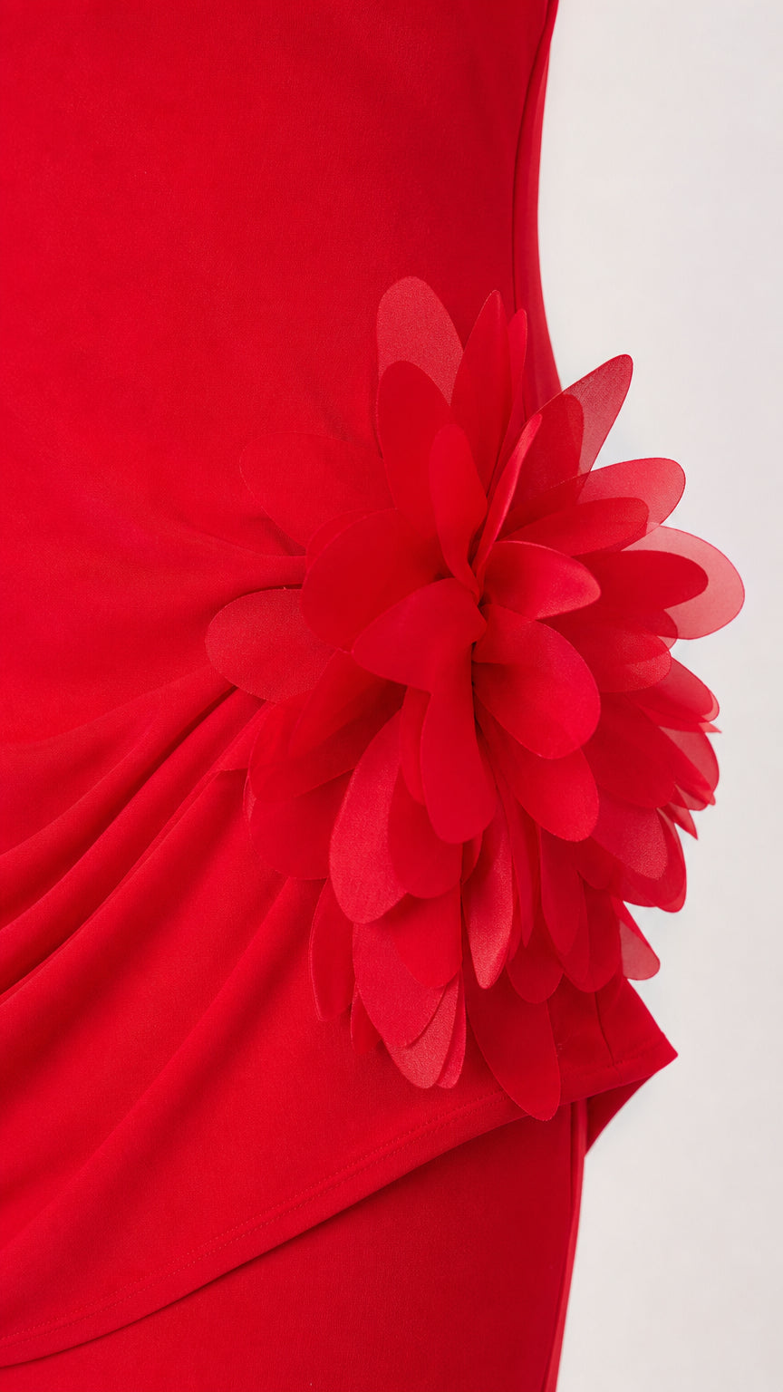 Close-up detail of red 3D floral appliqué and gathered draping on gown