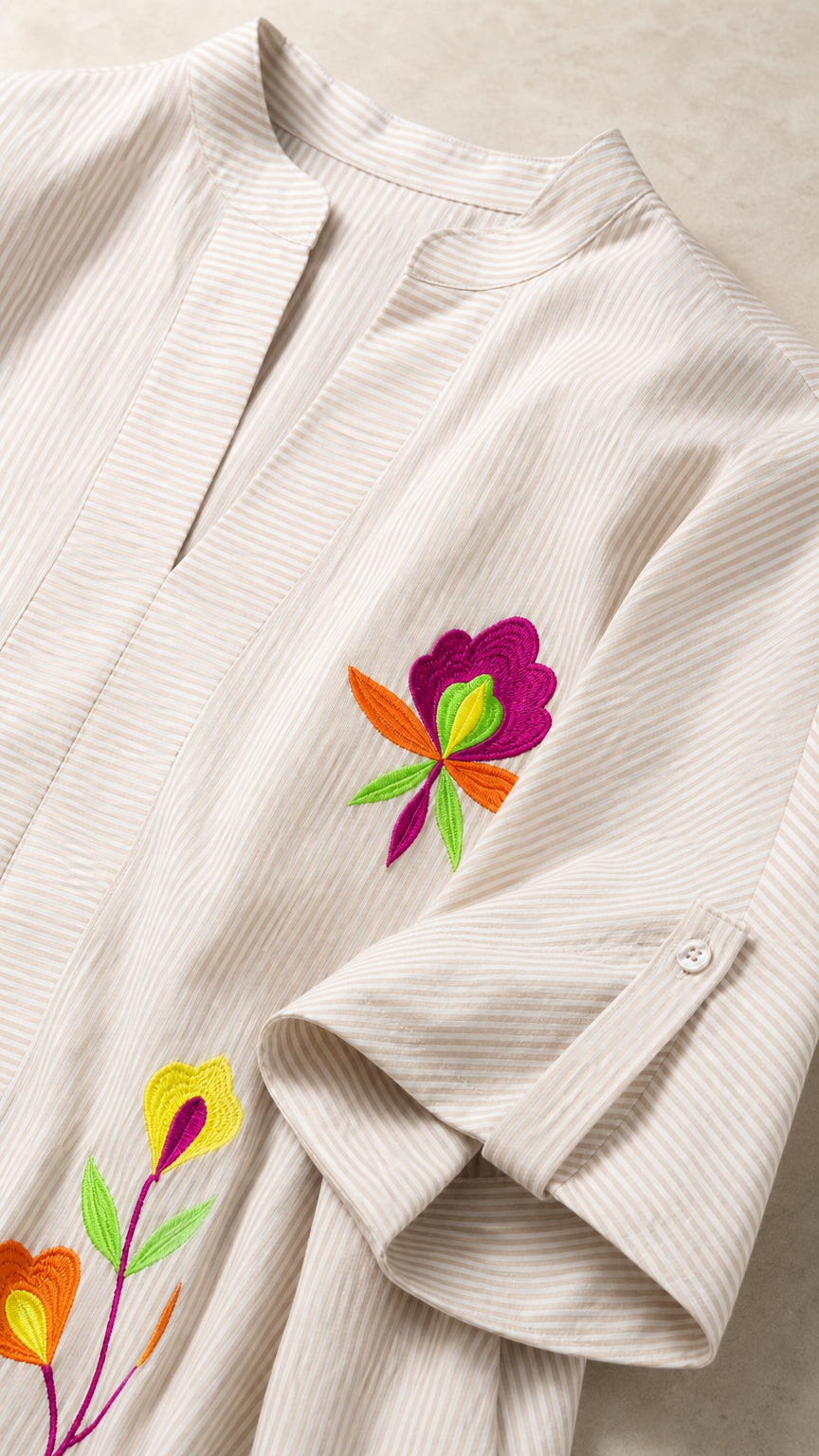 Close-up of floral embroidery and sleeve detail on beige tunic