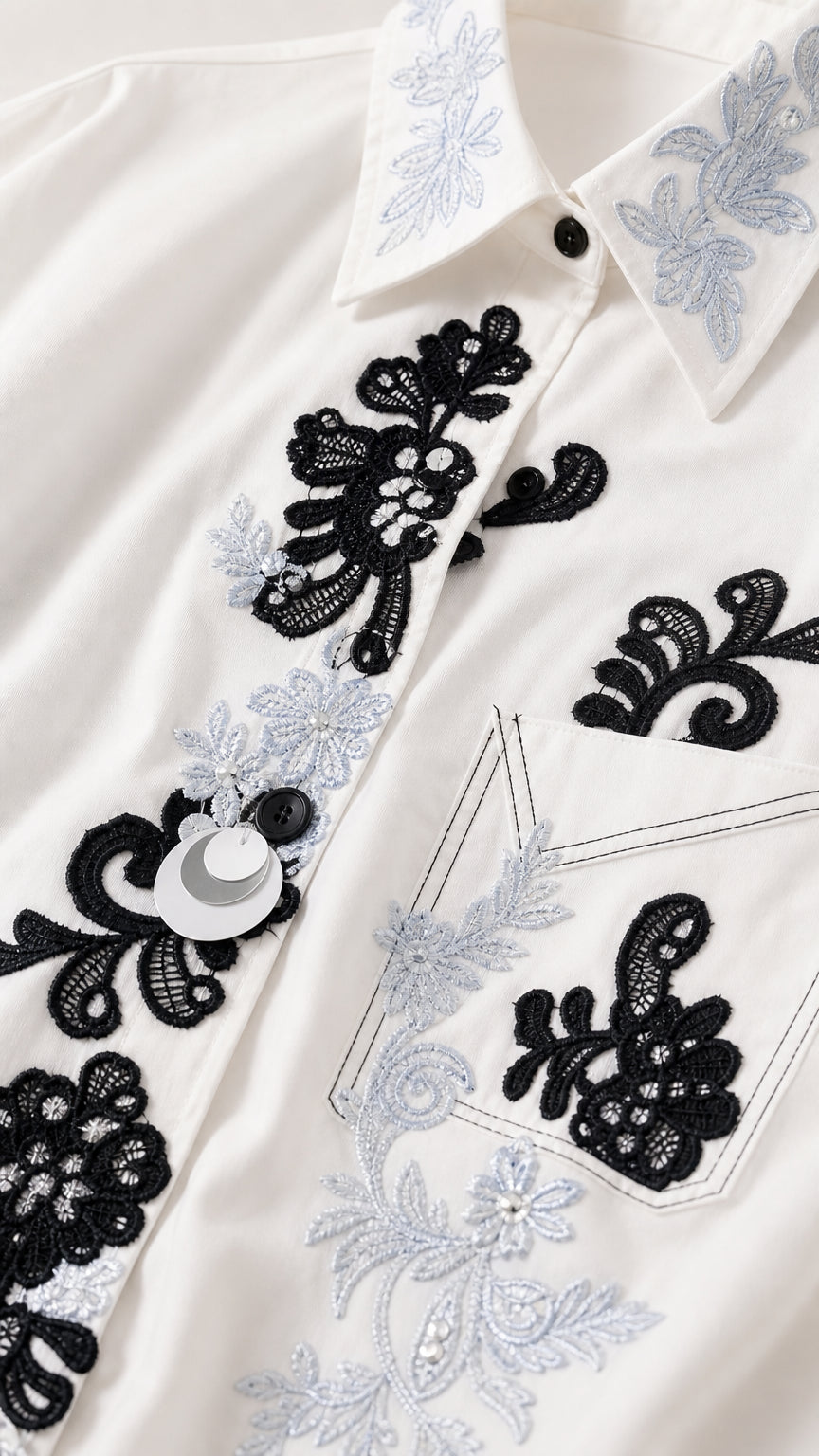 Close-up detail of floral embroidery and buttons on shirt collar