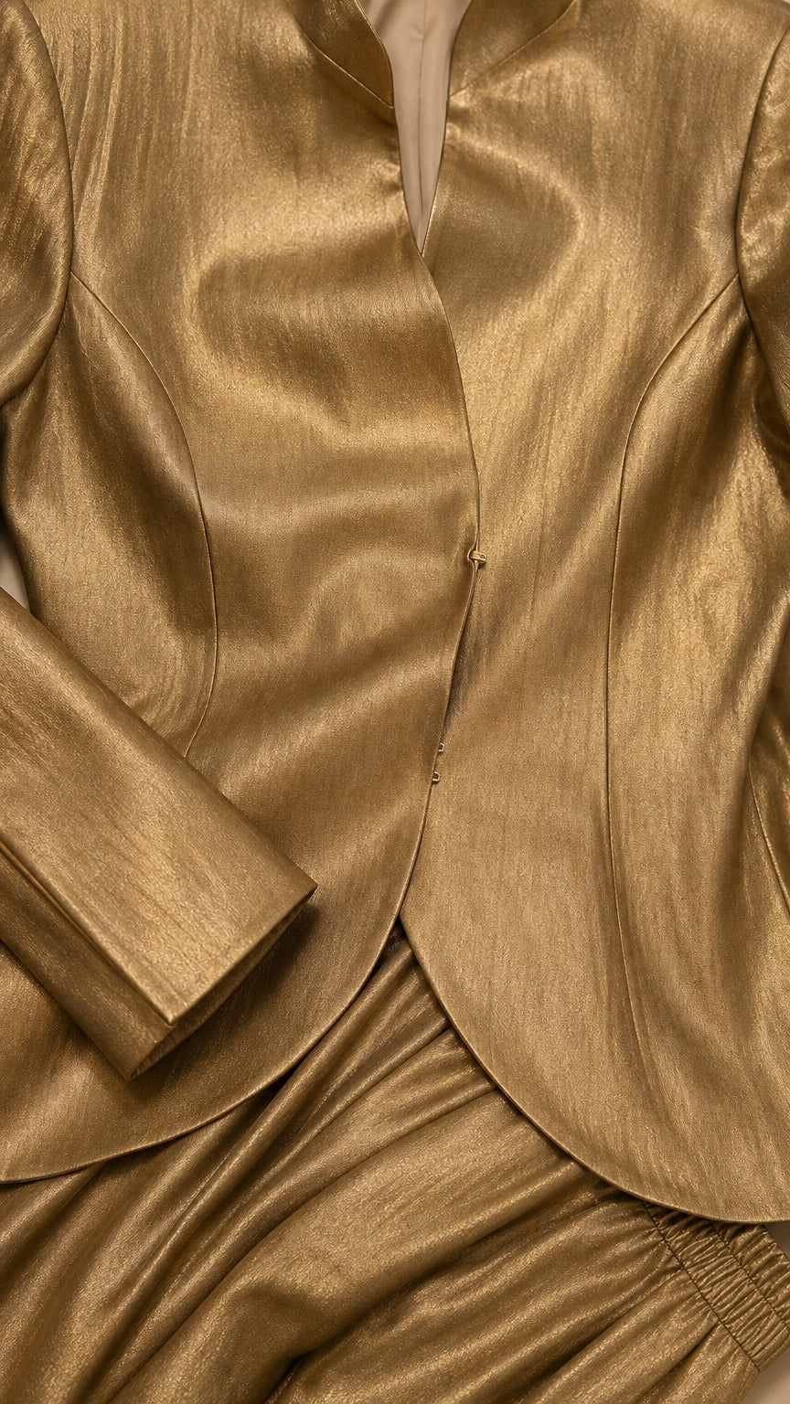 Close-up detail of metallic gold jacket lapel and button closure