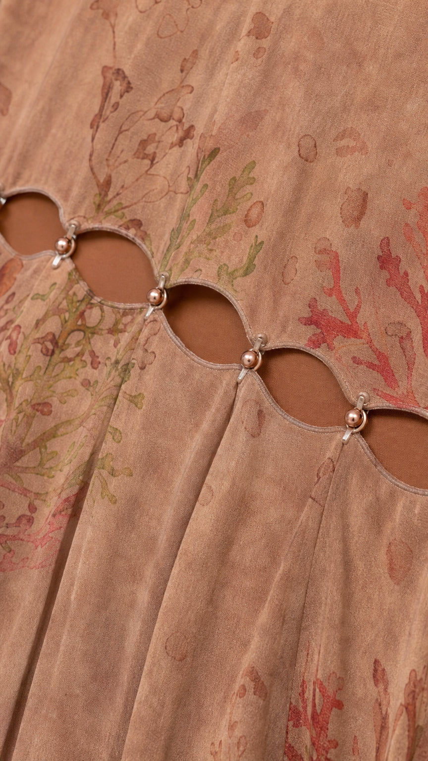 Close-up detail of cutout waist and hardware on brown dress