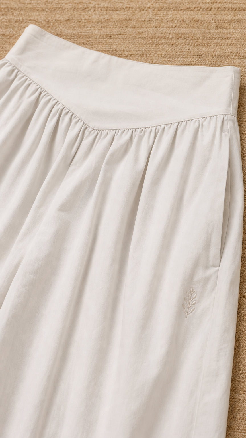 Close-up detail of the waistband and fabric texture of the beige pants