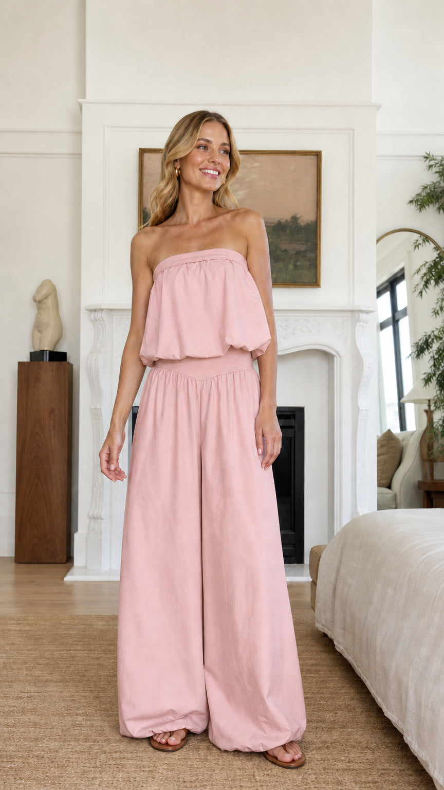 Model wearing soft pink strapless ruffle crop top and wide leg pants set