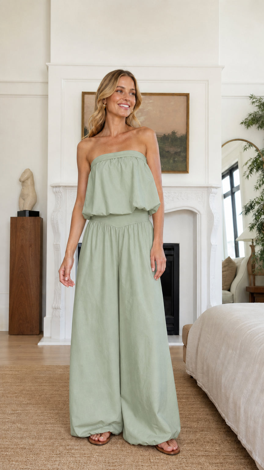 Model wearing sage green strapless ruffle crop top and wide leg pants set